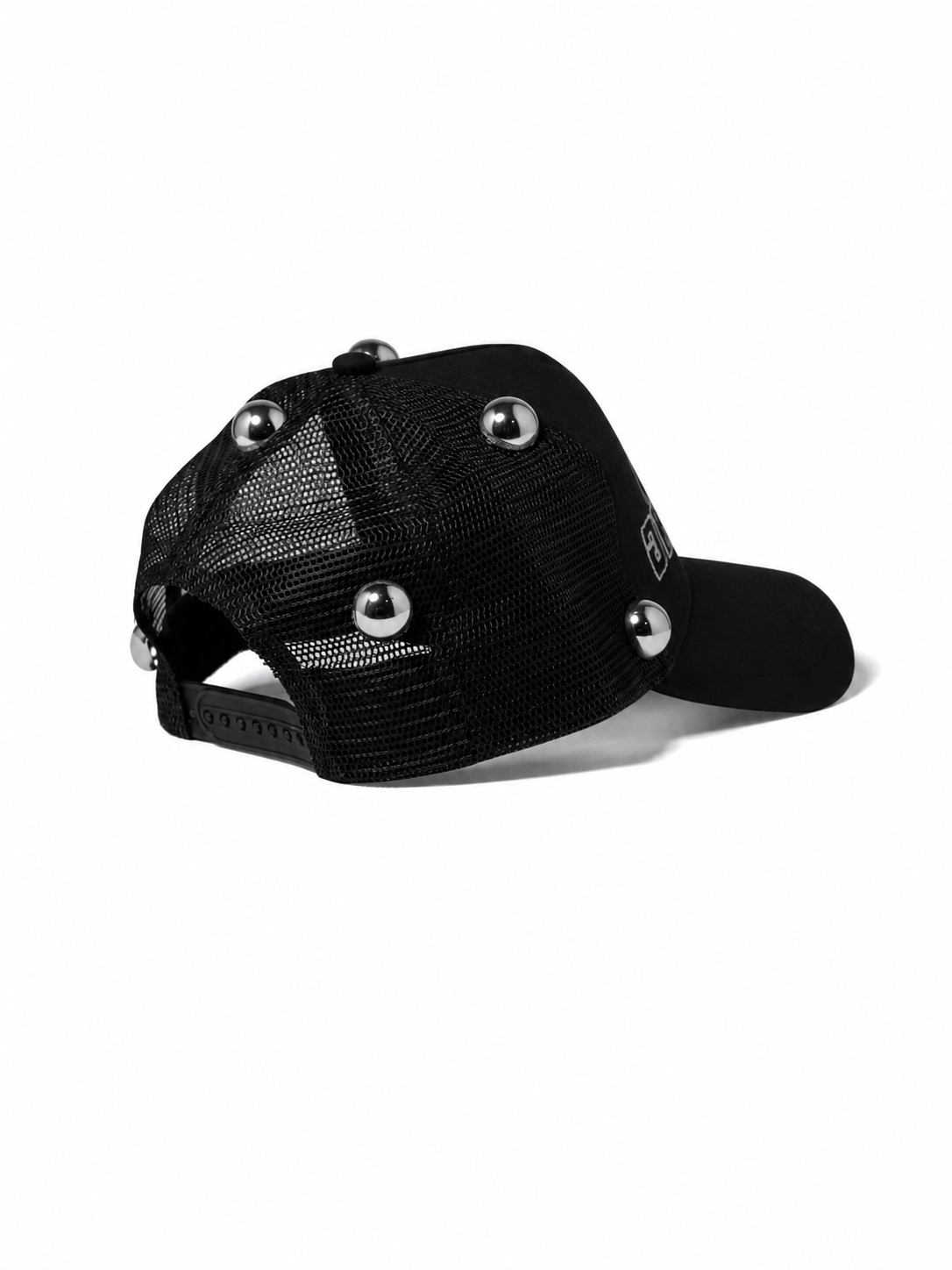 A black trucker-style cap with a mesh back and decorative silver metal studs on the front and brim, shown against a plain white background.
